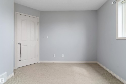 Light grey wall paint, light-colored carpet flooring, white trim, white paneled door, and a white window frame - 20845 92A Avenue Nw, Edmonton, AB - Indoor Photo Showing Other Room