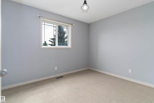 Light gray wall paint, textured ceiling, a window with white trim, and a black wire cage light fixture - 20845 92A Avenue Nw, Edmonton, AB - Indoor Photo Showing Other Room