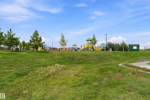 Expansive green space featuring a paved pathway, mature trees, and a playground with multiple structures - 20845 92A Avenue Nw, Edmonton, AB - Outdoor With View