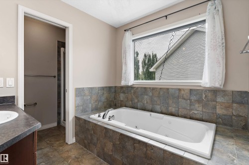 Built-in soaking tub with tiled surround, single vanity with integrated sink, and a separate shower enclosure - 20845 92A Avenue Nw, Edmonton, AB - Indoor Photo Showing Bathroom