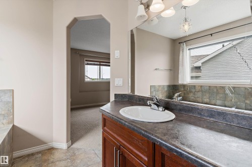 Vanity with a laminate countertop, undermount sink, and wood-finish cabinetry - 20845 92A Avenue Nw, Edmonton, AB - Indoor Photo Showing Bathroom
