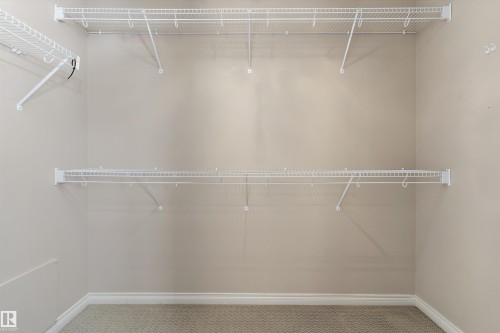 White wire shelving system, light-colored wall paint, and textured carpeting - 20845 92A Avenue Nw, Edmonton, AB - Indoor With Storage