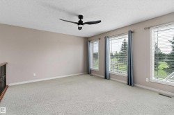 Expansive room featuring multiple windows, neutral wall tones, and a ceiling fan - 