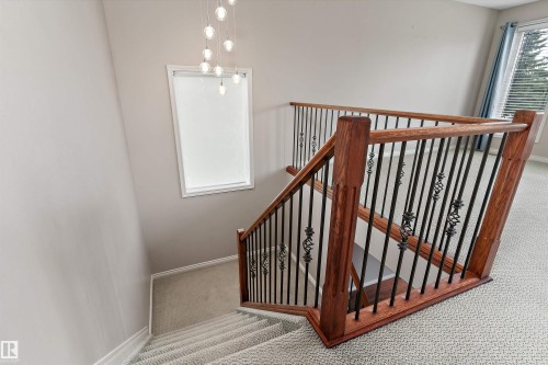 Staircase with wood-finish handrails, decorative wrought iron balusters, and carpeted treads - 20845 92A Avenue Nw, Edmonton, AB - Indoor Photo Showing Other Room