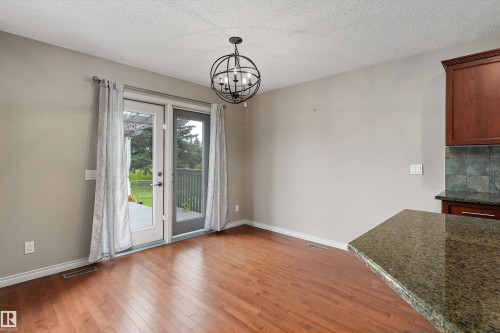 Hardwood flooring, double patio doors, orb-style chandelier, granite countertop, and tiled backsplash - 20845 92A Avenue Nw, Edmonton, AB - Indoor Photo Showing Other Room