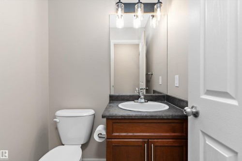 Bathroom with a wood-finish vanity, integrated sink, and dark countertop - 20845 92A Avenue Nw, Edmonton, AB - Indoor Photo Showing Bathroom