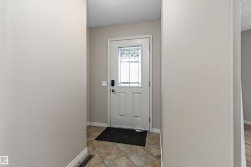 Entryway with a white paneled door featuring decorative glass, a smart lock, and tile flooring - 20845 92A Avenue Nw, Edmonton, AB - Indoor Photo Showing Other Room