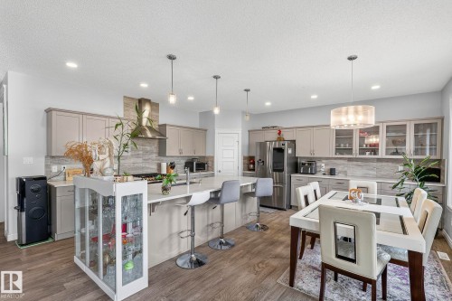 Open-concept kitchen with wood-finish flooring, recessed lighting, and a kitchen island - 923 174St Sw, Edmonton, AB 