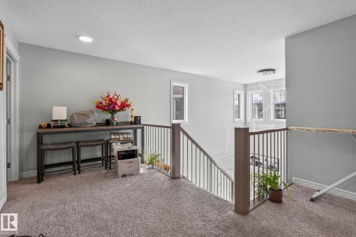 Loft space with recessed lighting, carpet flooring, a white ceiling, and a modern staircase with dark railing - 923 174St Sw, Edmonton, AB 