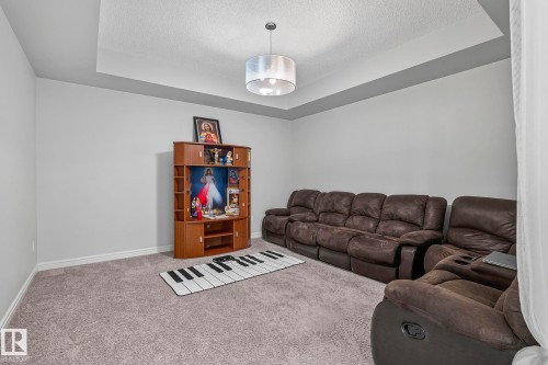 Tray ceiling with a central pendant light fixture and light gray wall paint - 923 174St Sw, Edmonton, AB 