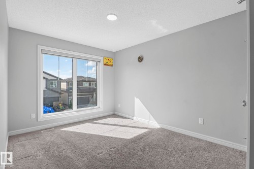 Wall-to-wall carpeting, expansive window, light gray wall finishes, and recessed ceiling lighting - 923 174St Sw, Edmonton, AB 