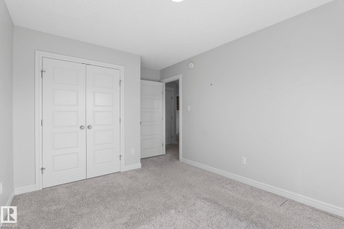 Neutral wall paint, plush carpet flooring, white trim, and white paneled doors - 923 174St Sw, Edmonton, AB 