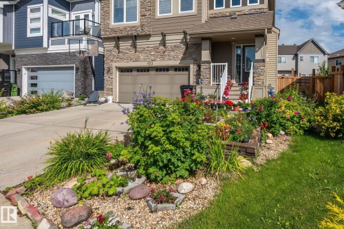 Two-story home with a stone and siding facade, covered front entry, and an attached two-car garage - 923 174St Sw, Edmonton, AB 