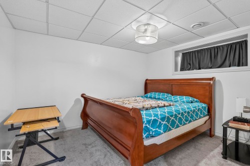 White walls, dropped ceiling with integrated lighting, window with white trim, and gray carpet flooring - 923 174St Sw, Edmonton, AB 