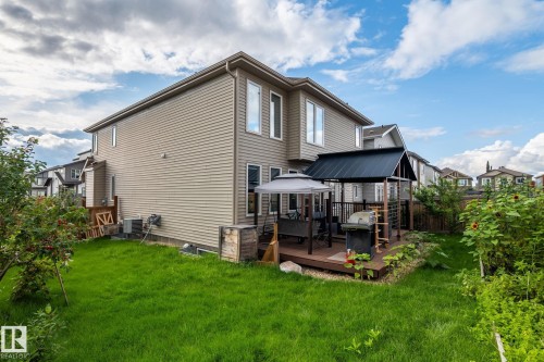 Expansive backyard featuring a manicured lawn, a multi-level wood-finish deck, and a built-in pergola - 923 174St Sw, Edmonton, AB 
