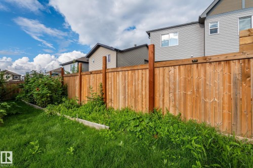 Expansive backyard featuring a natural wood fence and a raised garden bed - 923 174St Sw, Edmonton, AB 