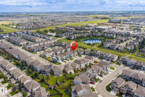 Residential neighborhood with varied architectural styles, green spaces, and a central pond - 923 174St Sw, Edmonton, AB 