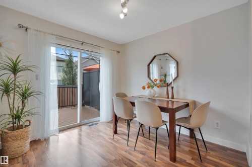 Wood-finish flooring throughout, with light-toned walls and a built-in overhead light fixture - 17321 8A Avenue Sw, Edmonton, AB - Indoor Photo Showing Dining Room