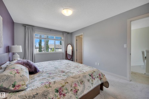 Neutral wall color, carpet flooring, a flush mount ceiling light fixture, and a window with blinds - 17321 8A Avenue Sw, Edmonton, AB - Indoor Photo Showing Bedroom