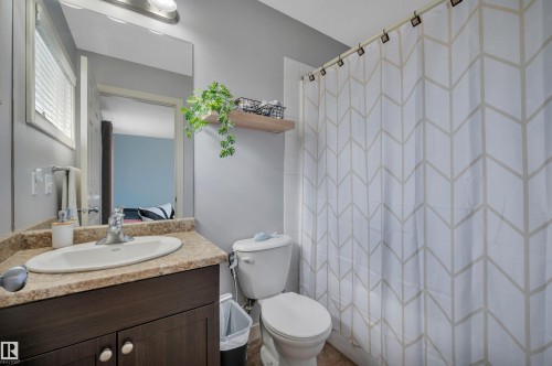 Vanity with a light-colored countertop and under-sink storage - 17321 8A Avenue Sw, Edmonton, AB - Indoor Photo Showing Bathroom