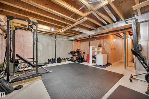 Unfinished basement with exposed ceiling joists and concrete walls, featuring recessed lighting and a section of rubber flooring - 17321 8A Avenue Sw, Edmonton, AB - Indoor Photo Showing Basement