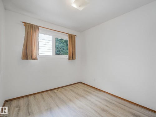 Wood-finish flooring with coordinating wood trim - 16428 88 Avenue Nw, Edmonton, AB - Indoor Photo Showing Other Room