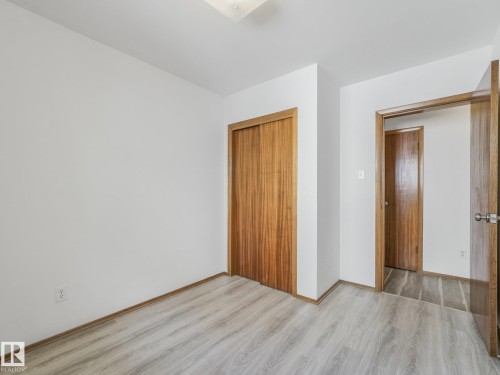 Light wood-finish flooring with a neutral wall color - 16428 88 Avenue Nw, Edmonton, AB - Indoor Photo Showing Other Room