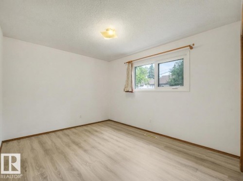 Light-toned wood-finish flooring, white walls, and a multi-pane window - 16428 88 Avenue Nw, Edmonton, AB - Indoor Photo Showing Other Room