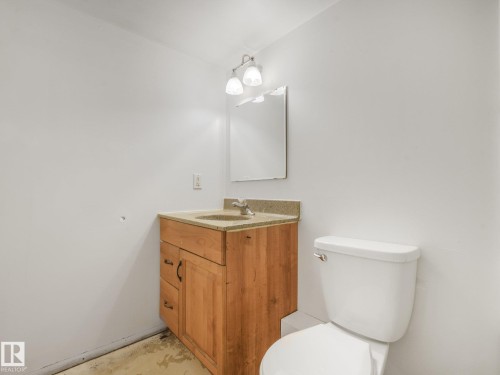 Wood-finish vanity with a surface-mounted sink, light-toned countertop, and chrome faucet - 16428 88 Avenue Nw, Edmonton, AB - Indoor Photo Showing Bathroom