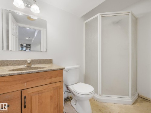 Wood-finish vanity with an integrated sink and granite-style countertop - 16428 88 Avenue Nw, Edmonton, AB - Indoor Photo Showing Bathroom