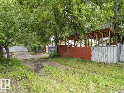 Enclosed patio structure with exposed wood framing, wood panel fencing, and chain link fencing - 16428 88 Avenue Nw, Edmonton, AB - Outdoor