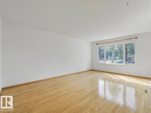 Light-filled room featuring wood-finish flooring and large windows - 16428 88 Avenue Nw, Edmonton, AB - Indoor Photo Showing Other Room
