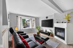 Bay window with multiple panes, crown molding, wood-finish flooring, built-in fireplace, and white painted mantel - 