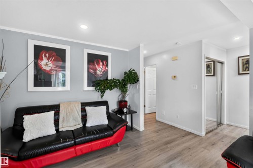 Recessed ceiling lighting, crown molding, light wood-finish flooring, and a mirrored closet door - #28 3645 145 Av Nw, Edmonton, AB - Indoor