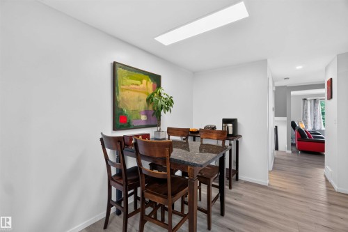 Recessed ceiling lighting, wood-finish flooring, and a skylight feature in this space - #28 3645 145 Av Nw, Edmonton, AB - Indoor Photo Showing Dining Room