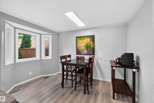 Wood-finish flooring, bay window, recessed ceiling light, white trim, and neutral wall paint - #28 3645 145 Av Nw, Edmonton, AB - Indoor Photo Showing Other Room