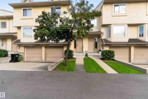 Three-story townhouse exterior with multiple windows, bay windows, and attached garages - #28 3645 145 Av Nw, Edmonton, AB - Outdoor With Facade