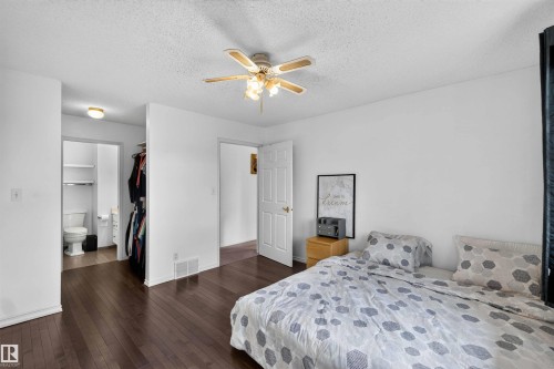 Bedroom with wood-finish flooring, ceiling fan with integrated lighting, and an adjacent closet space - #28 3645 145 Av Nw, Edmonton, AB - Indoor Photo Showing Bedroom