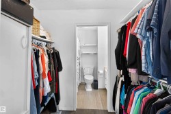 Walk-in closet featuring built-in shelving, hanging rods, and a sliding closet door - 