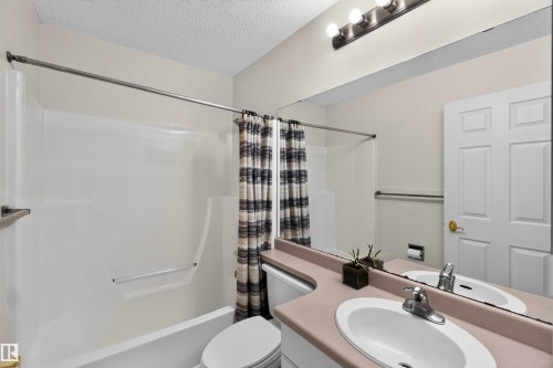 Single-piece vanity with integrated oval sink, full-width wall mirror, and three-bulb vanity light - #28 3645 145 Av Nw, Edmonton, AB - Indoor Photo Showing Bathroom