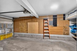 Concrete flooring, wood paneling, overhead lighting, garage door, built-in shelving - 