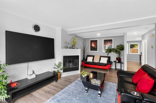 Living area with a fireplace, recessed lighting, and wood-finish flooring - #28 3645 145 Av Nw, Edmonton, AB - Indoor Photo Showing Living Room With Fireplace