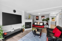 Living area with a fireplace, recessed lighting, and wood-finish flooring - 