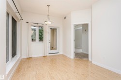 Wood-finish flooring, multiple windows, a glass-paned door, and a suspended lighting fixture - 