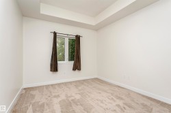 Recessed ceiling detail, neutral-toned carpeting, white walls, and a window for natural light - 