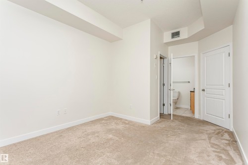 Neutral carpet flooring, white walls, and white trim - #219 10333 112 St Nw, Edmonton, AB - Indoor Photo Showing Other Room