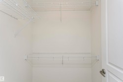 Built-in wire shelving system with hanging rods and white walls - 