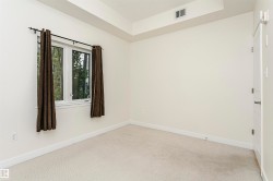 Neutral tone wall finish, white trim, recessed lighting, white panel door, and light-colored carpeting - 
