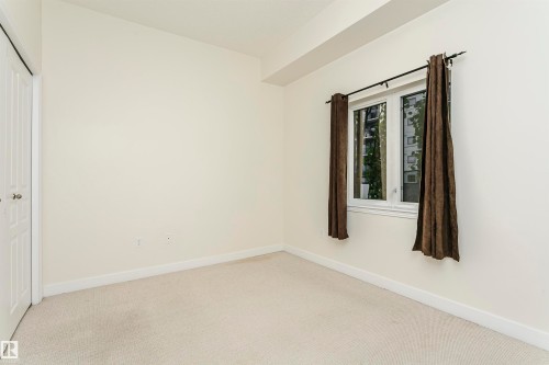 Neutral wall tones, white trim, and light-colored carpeting - #219 10333 112 St Nw, Edmonton, AB - Indoor Photo Showing Other Room