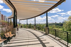 Curved pergola structure with a slatted roof and dark-toned support columns - 